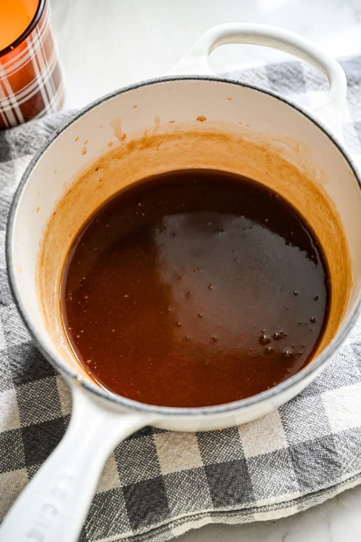 Finished date caramel sauce in a small white saucepan.