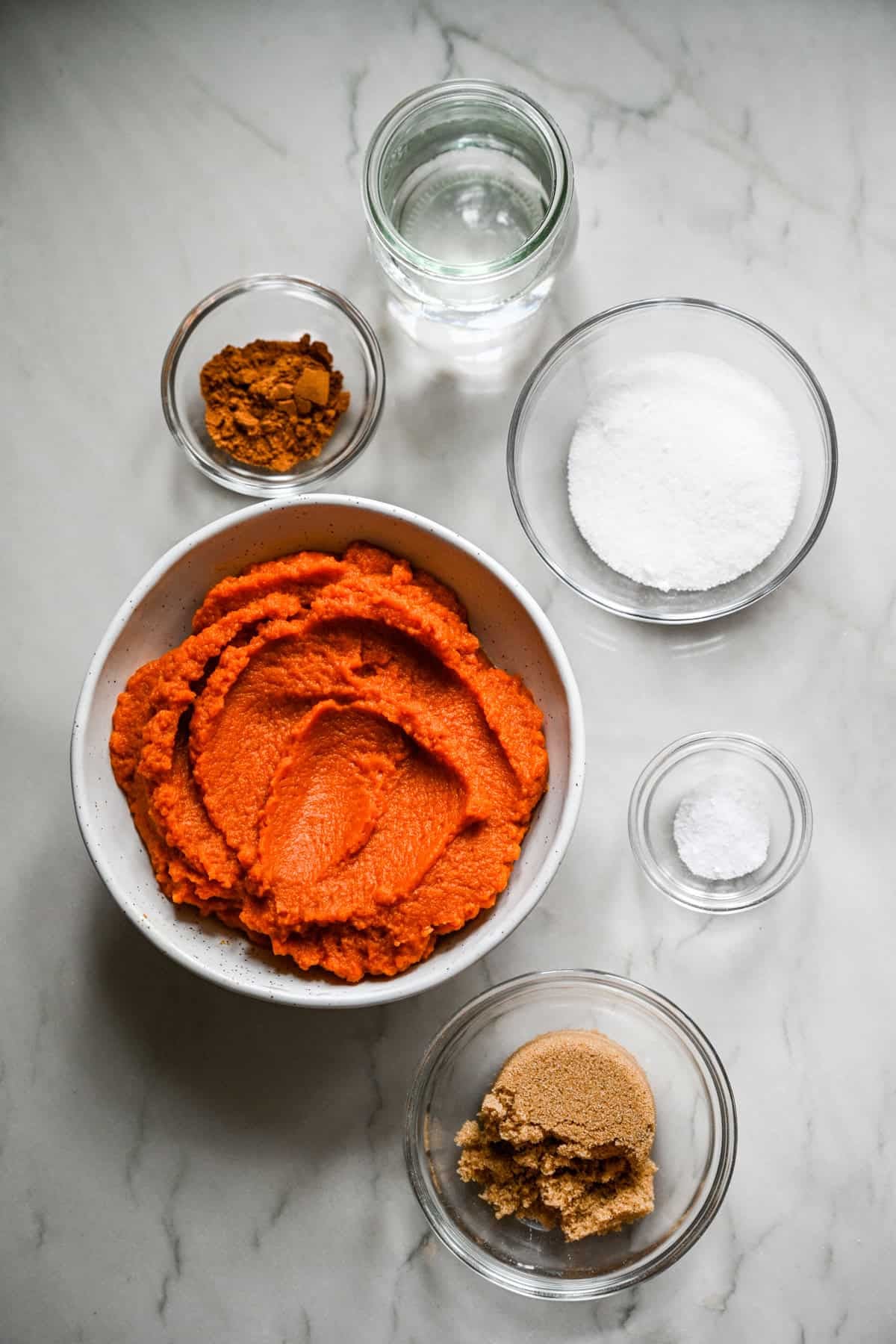 overhead view of ingredients for homemade pumpkin butter in small prep bowls.