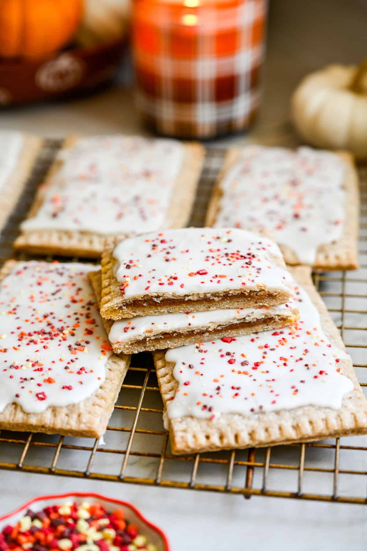 Close up view of homemade pumpkin pie pop tart cut in half to show filling and stacked on top of more pop tarts.