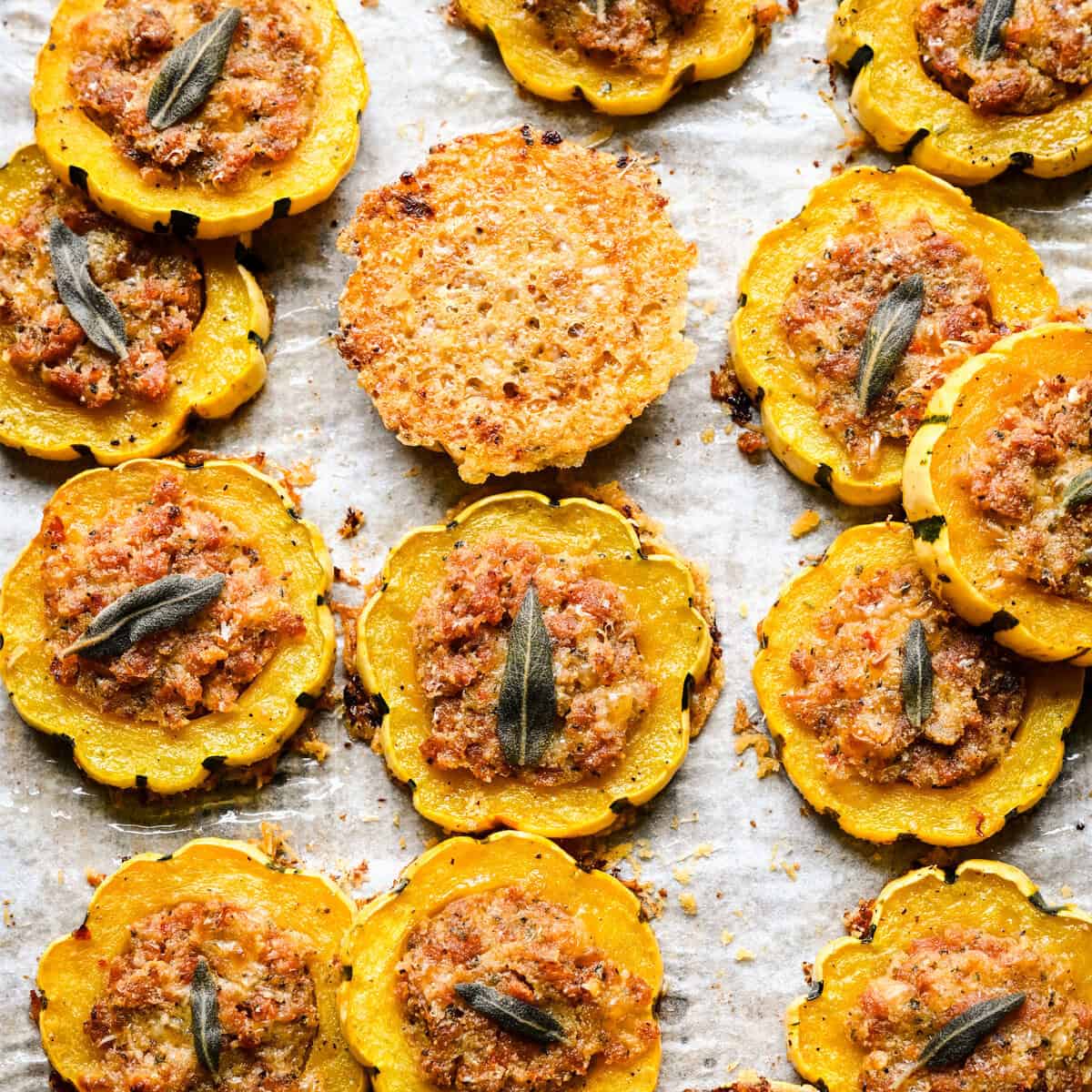 Close up overhead view of stuffed delicata squash rings around a single parmesan crisp.
